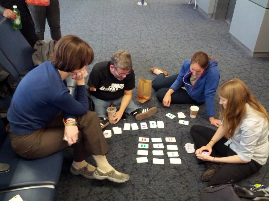 Erin teaches her colleagues how to play Set at the airport.